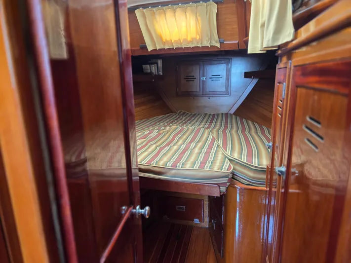 Perelandra Yacht Photos Pics 1968 Hinckley Bermuda 40 cabin interior with striped bedding and wooden finish.