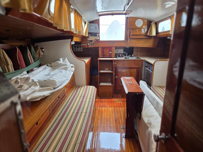 Perelandra Yacht Photos Pics 1968 Hinckley Bermuda 40 yacht interior with wood finish, cozy seating, and compact kitchen.