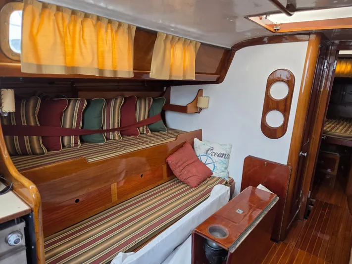 Perelandra Yacht Photos Pics Interior of 1968 Hinckley Bermuda 40 sailboat with striped cushions and wooden finishes.