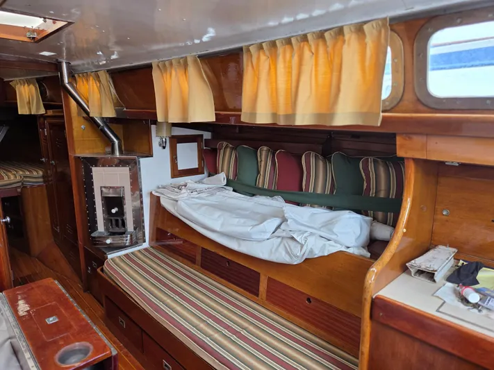 Perelandra Yacht Photos Pics Interior of 1968 Hinckley Bermuda 40 sailboat with wood finish and striped cushions.