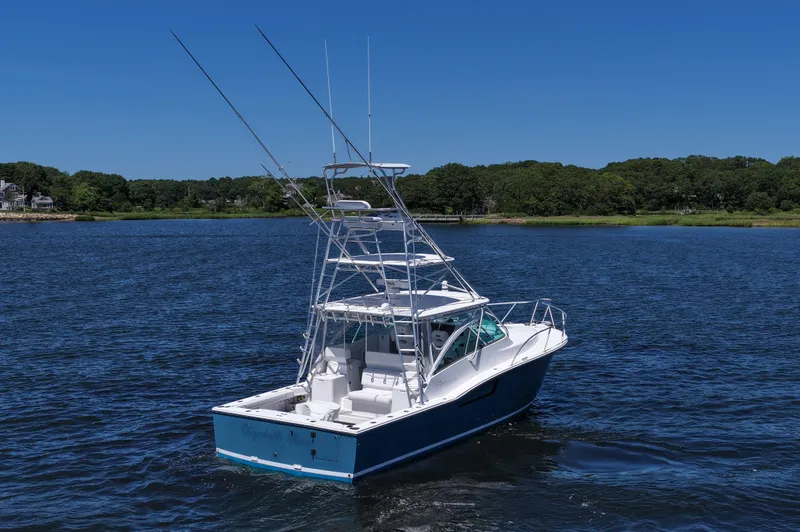  Yacht Photos Pics 2018 Albemarle 36 Express boat on a serene lake with lush green shoreline.