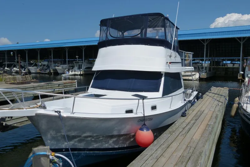  Yacht Photos Pics 1999 Mainship 350 Trawler docked at marina under blue sky.
