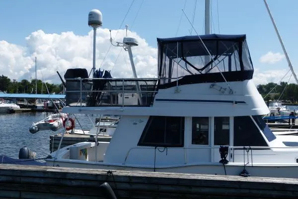  Yacht Photos Pics 1999 Mainship 350 Trawler docked at a marina under a clear blue sky.