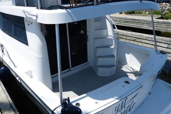  Yacht Photos Pics 1999 Mainship 350 Trawler, rear view with stairs and deck, docked at marina.