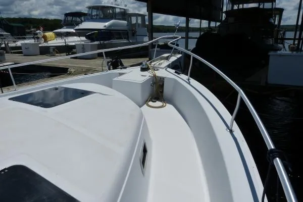  Yacht Photos Pics 1999 Mainship 350 Trawler docked, showcasing bow and railing under cloudy sky.