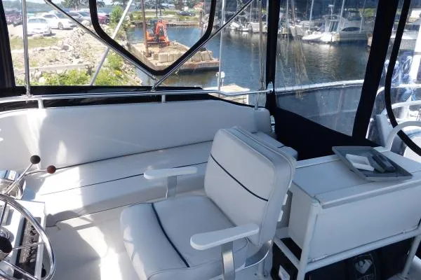  Yacht Photos Pics 1999 Mainship 350 Trawler cockpit with white seating, marina view in background.