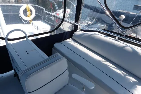  Yacht Photos Pics 1999 Mainship 350 Trawler interior with seating and helm, featuring a clear view of the water.
