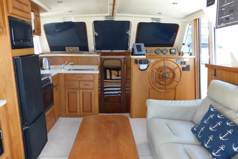  Yacht Photos Pics Interior of 1999 Mainship 350 Trawler with helm, kitchen, and seating area.