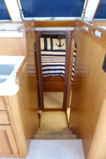  Yacht Photos Pics 1999 Mainship 350 Trawler interior with wooden stairs leading to a cozy cabin.