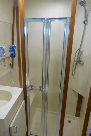  Yacht Photos Pics 1999 Mainship 350 Trawler bathroom with shower, sink, and sliding glass door.