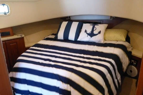  Yacht Photos Pics 1999 Mainship 350 Trawler cabin with nautical-themed bedding and anchor pillow.