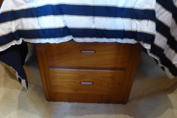  Yacht Photos Pics Wooden drawer unit under striped bedding on Mainship 350 Trawler, 1999 model.