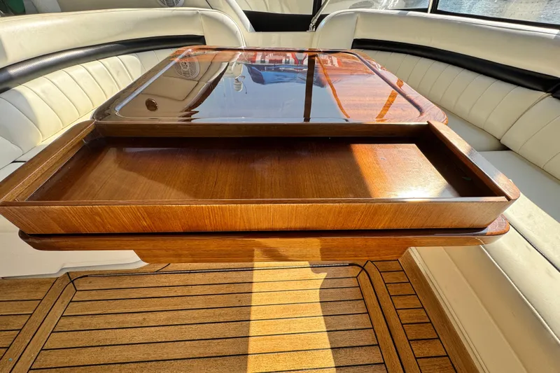  Yacht Photos Pics Luxurious wooden table on 2006 Sea Ray 48 Sundancer yacht, surrounded by cream seating.