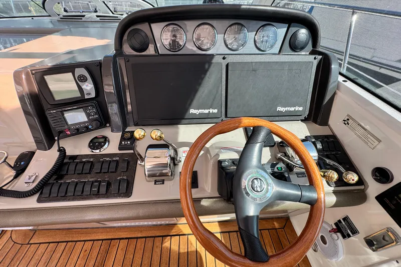  Yacht Photos Pics Helm of 2006 Sea Ray 48 Sundancer with Raymarine electronics and wooden steering wheel.
