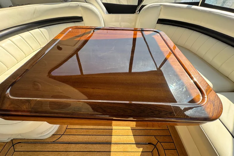  Yacht Photos Pics Luxurious interior of 2006 Sea Ray 48 Sundancer with polished wood table and leather seating.