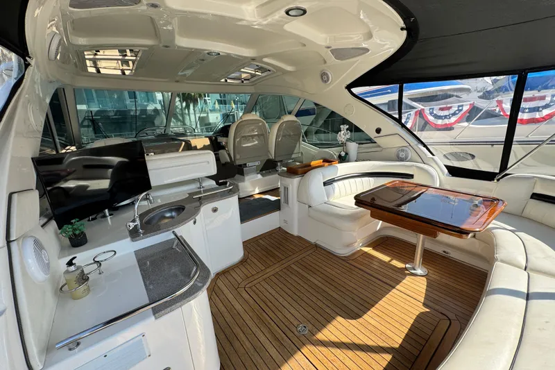  Yacht Photos Pics Luxurious interior of 2006 Sea Ray 48 Sundancer yacht with seating, table, and kitchenette.