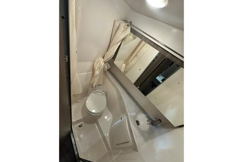  Yacht Photos Pics 2022 Regal 28 Express bathroom with toilet, sink, and mirror.
