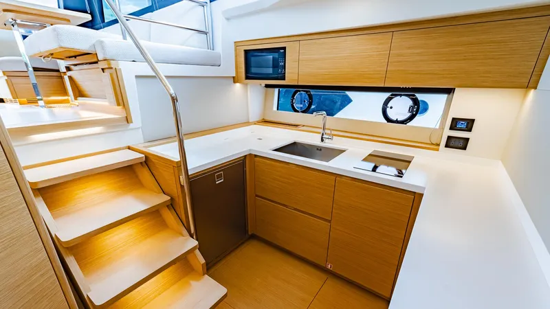 Available Now Yacht Photos Pics Modern kitchen interior of 2024 Pardo Yachts GT52 with wooden cabinetry and sleek design.