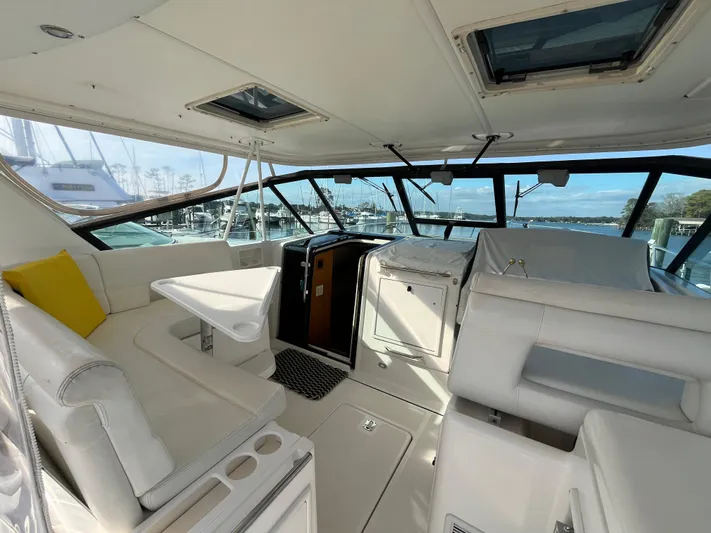  Yacht Photos Pics 2001 Tiara Yachts 4100 Open interior with white seating and table, docked at marina.