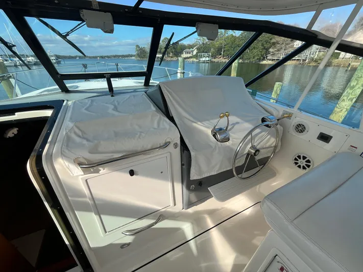  Yacht Photos Pics 2001 Tiara Yachts 4100 Open helm with covered controls, overlooking serene waterfront.