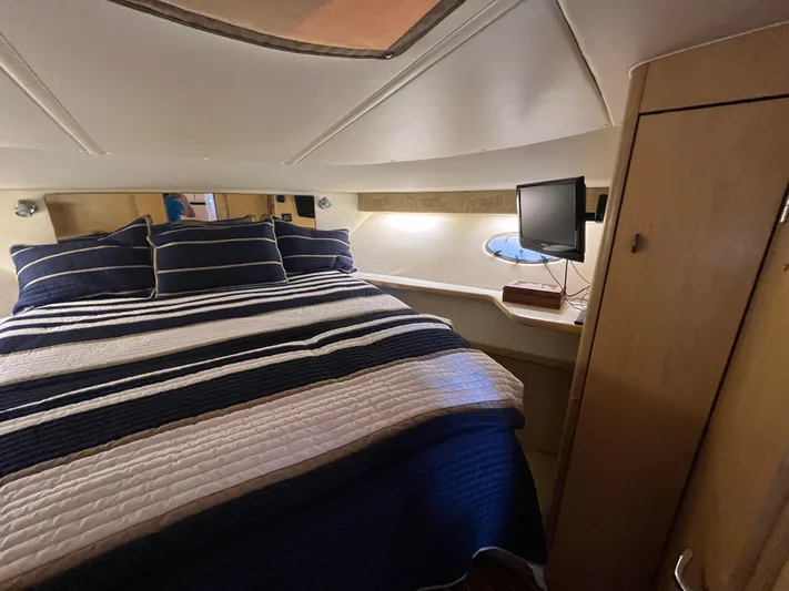  Yacht Photos Pics Cozy bedroom in 2001 Tiara Yachts 4100 Open with striped bedding and small TV.