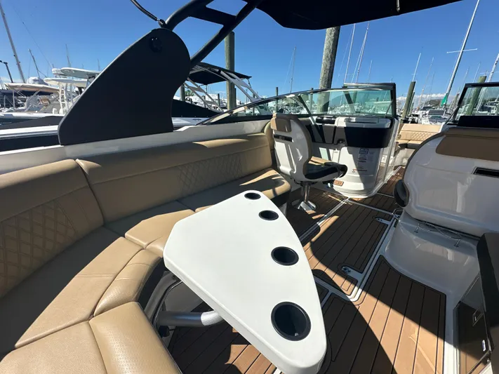  Yacht Photos Pics 2019 Sea Ray SLX 280 interior with tan seating, white table, and wood flooring.