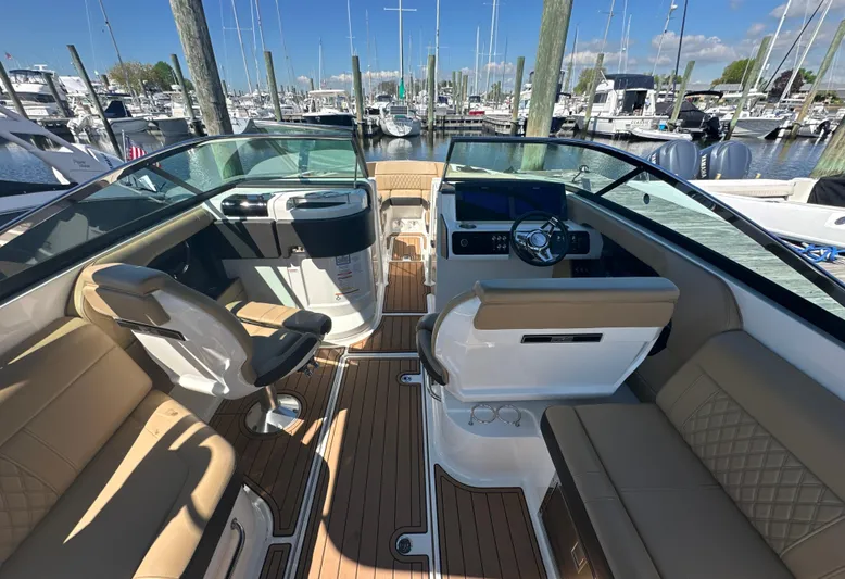  Yacht Photos Pics 2019 Sea Ray SLX 280 boat interior with tan seating and wood flooring at a marina.