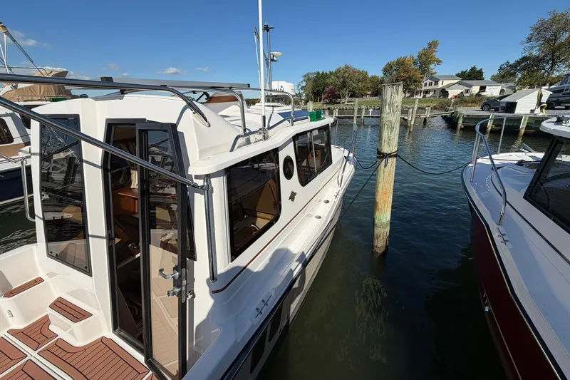 Getting There Yacht Photos Pics 2023 Ranger Tugs R-25 docked at a marina, showcasing sleek design and modern features.