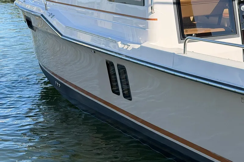 Getting There Yacht Photos Pics 2023 Ranger Tugs R-25 boat side view on water, showcasing sleek design.