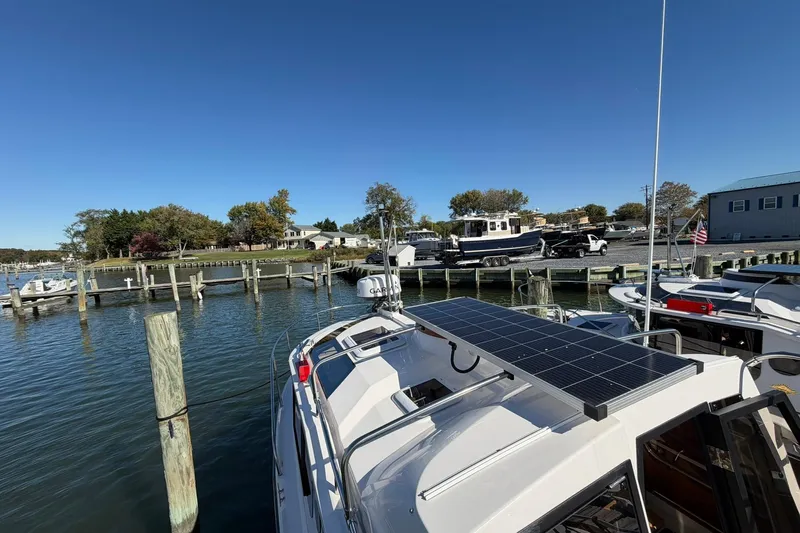 Getting There Yacht Photos Pics 2023 Ranger Tugs R-25 docked, featuring solar panels, under clear blue sky.