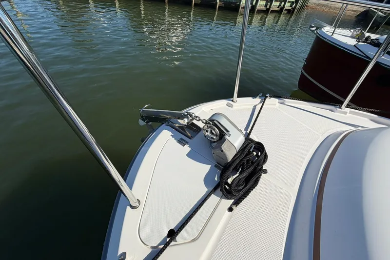 Getting There Yacht Photos Pics 2023 Ranger Tugs R-25 boat deck with anchor and rope, docked by the water.
