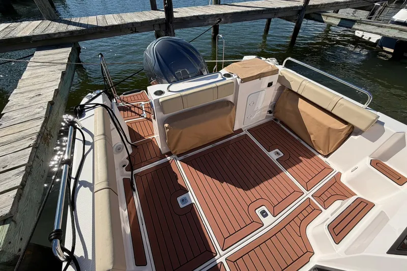 Getting There Yacht Photos Pics 2023 Ranger Tugs R-25 boat deck with wood finish and seating at dock.