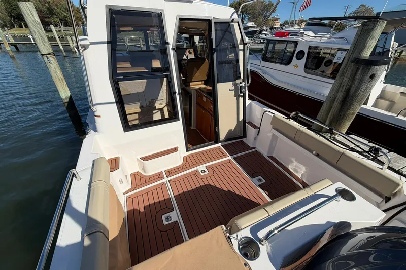 Getting There Yacht Photos Pics 2023 Ranger Tugs R-25 boat with open cabin door, docked at marina.