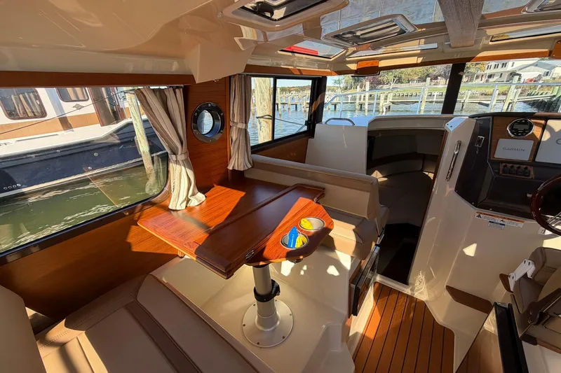 Getting There Yacht Photos Pics Interior of 2023 Ranger Tugs R-25 boat with wooden table and seating area.