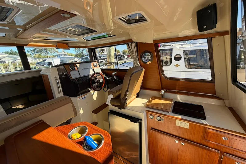 Getting There Yacht Photos Pics Interior of 2023 Ranger Tugs R-25 boat with helm, kitchen, and seating area.