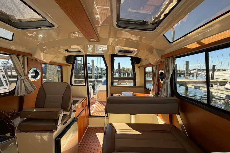 Getting There Yacht Photos Pics Interior of 2023 Ranger Tugs R-25 boat with elegant seating and panoramic windows.