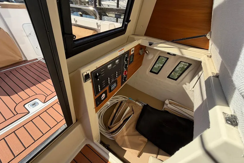 Getting There Yacht Photos Pics 2023 Ranger Tugs R-25 interior with control panel and wooden flooring.