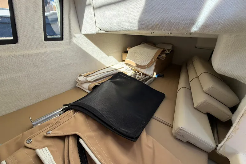 Getting There Yacht Photos Pics Interior cabin of 2023 Ranger Tugs R-25 with beige upholstery and storage items.