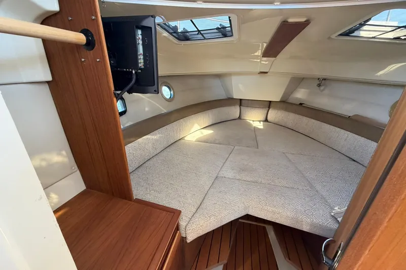 Getting There Yacht Photos Pics 2023 Ranger Tugs R-25 interior cabin with cozy seating and wooden accents.