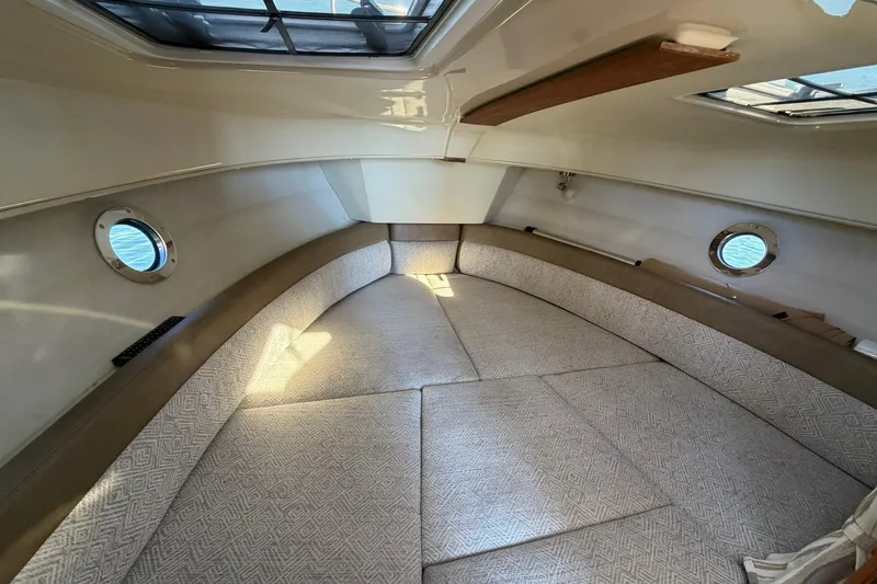 Getting There Yacht Photos Pics 2023 Ranger Tugs R-25 cabin interior with cozy seating and porthole windows.