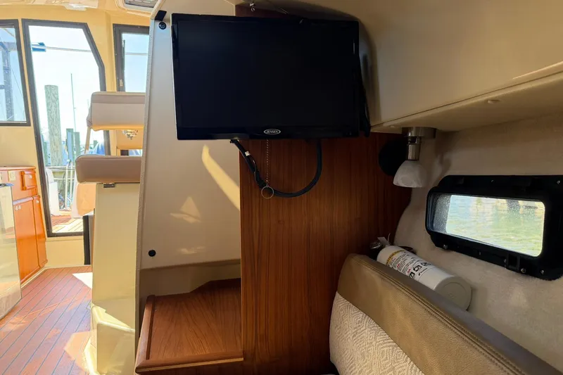 Getting There Yacht Photos Pics 2023 Ranger Tugs R-25 interior with TV, seating, and window view.