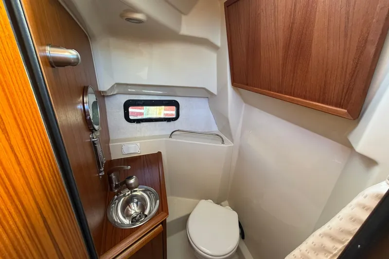 Getting There Yacht Photos Pics 2023 Ranger Tugs R-25 boat bathroom with wood accents and compact design.