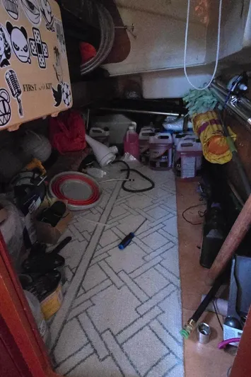 Lucy In The Sky Yacht Photos Pics Storage area inside a 2001 Beneteau Oceanis 473 sailboat, cluttered with various items.