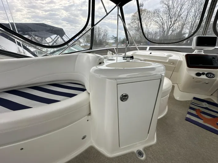  Yacht Photos Pics 2008 Meridian 391 Sedan interior with white seating, striped cushions, and a compact sink area.