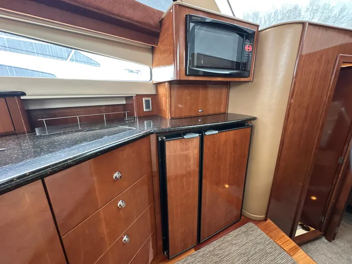  Yacht Photos Pics 2008 Meridian 391 Sedan yacht interior with wood cabinetry, microwave, and compact refrigerator.