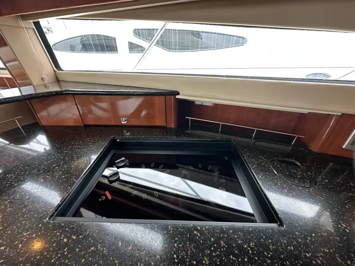  Yacht Photos Pics Luxurious 2008 Meridian 391 Sedan yacht kitchen with sleek black countertop and modern stove.