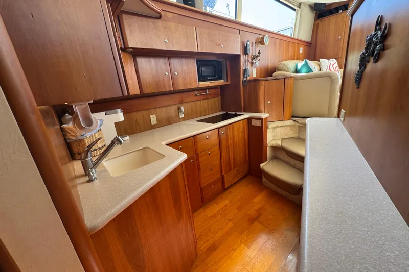 She's From Boston Yacht Photos Pics 2003 Silverton 42 Convertible yacht interior with wooden cabinetry and modern kitchen amenities.