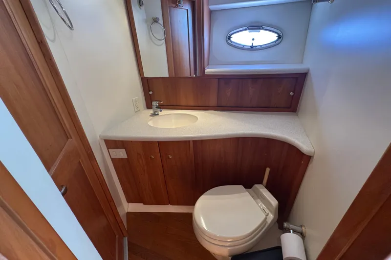She's From Boston Yacht Photos Pics 2003 Silverton 42 Convertible yacht bathroom with wooden cabinetry and compact design.