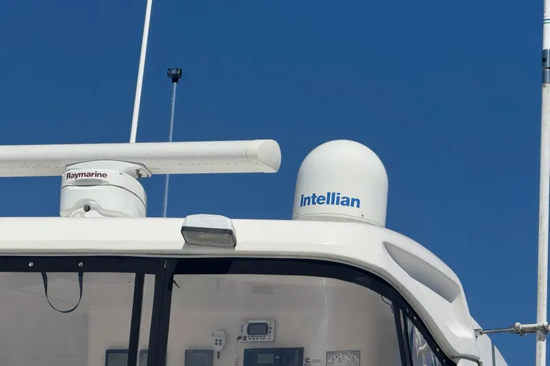 She's From Boston Yacht Photos Pics 2003 Silverton 42 Convertible boat with Raymarine and Intellian equipment against clear blue sky.