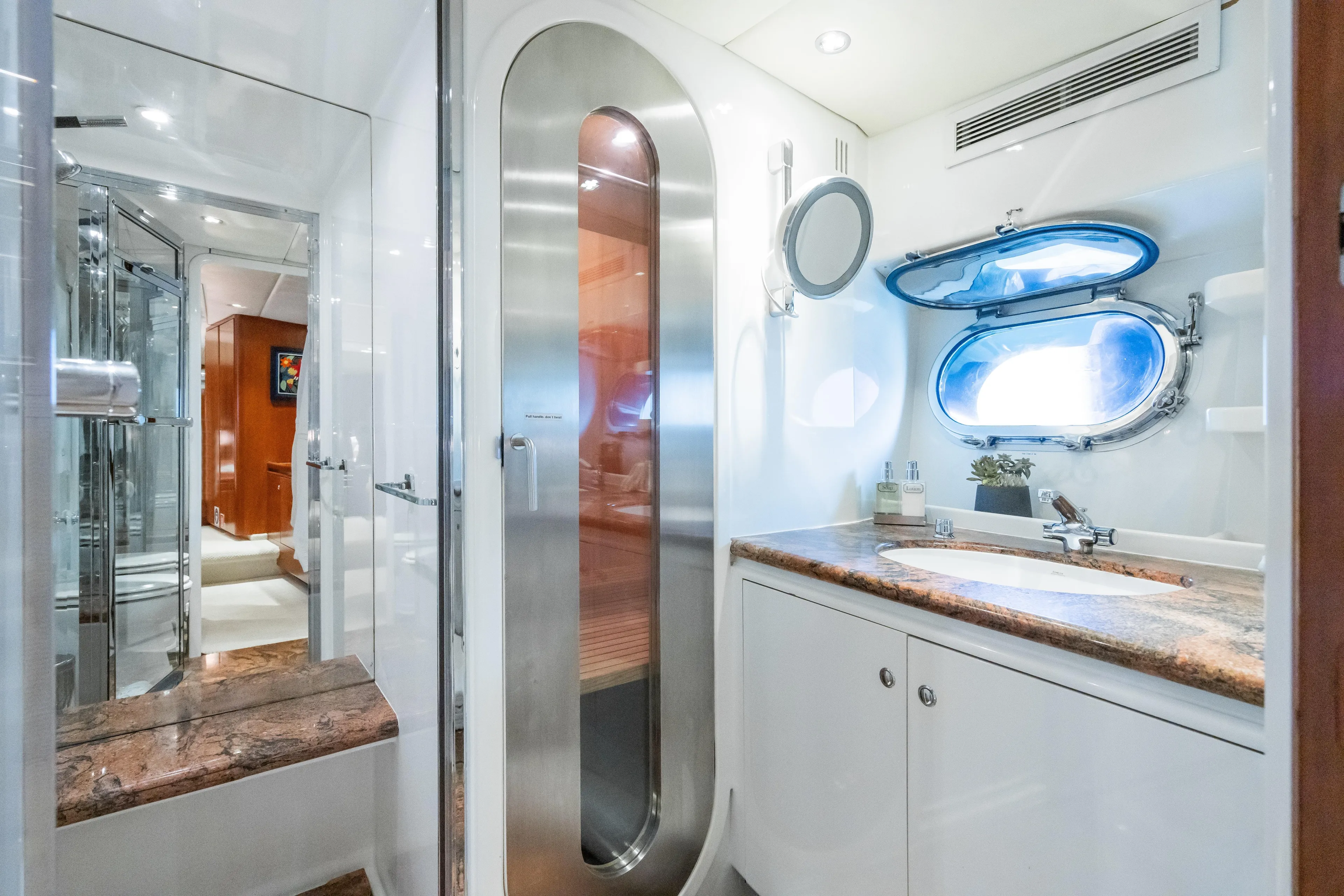 Seaquell Yacht Photos Pics Luxurious bathroom in a 1992 Alloy Yachts sailboat with modern fixtures and porthole window.